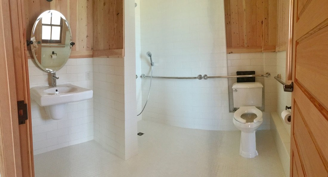 The Emig Cabin bathroom, with a roll-in shower, grab rails and a wall-hung basin