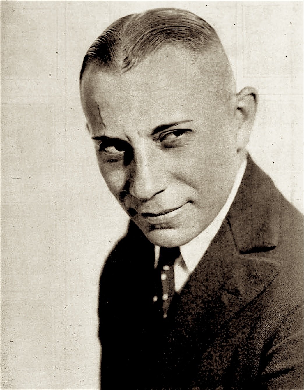 Portrait of Erich von Stroheim in a suit and tie, with a sly sideways look, 1919