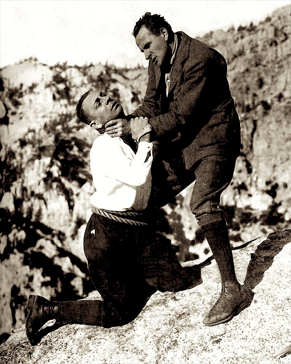 Publicity still: Stroheim and Sam De Grasse struggle on a rocky mountain peak