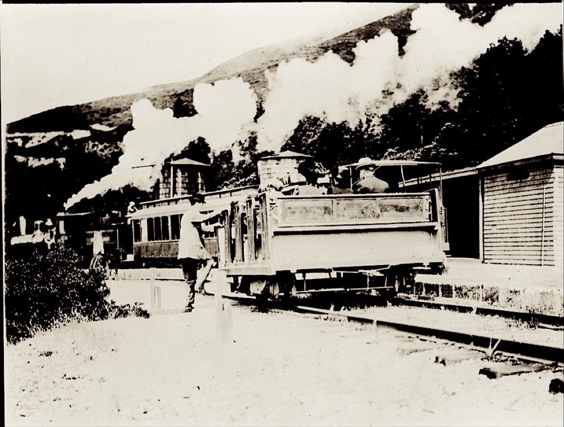 Passengers on an open gravity car beside a steam engine at Mesa Station