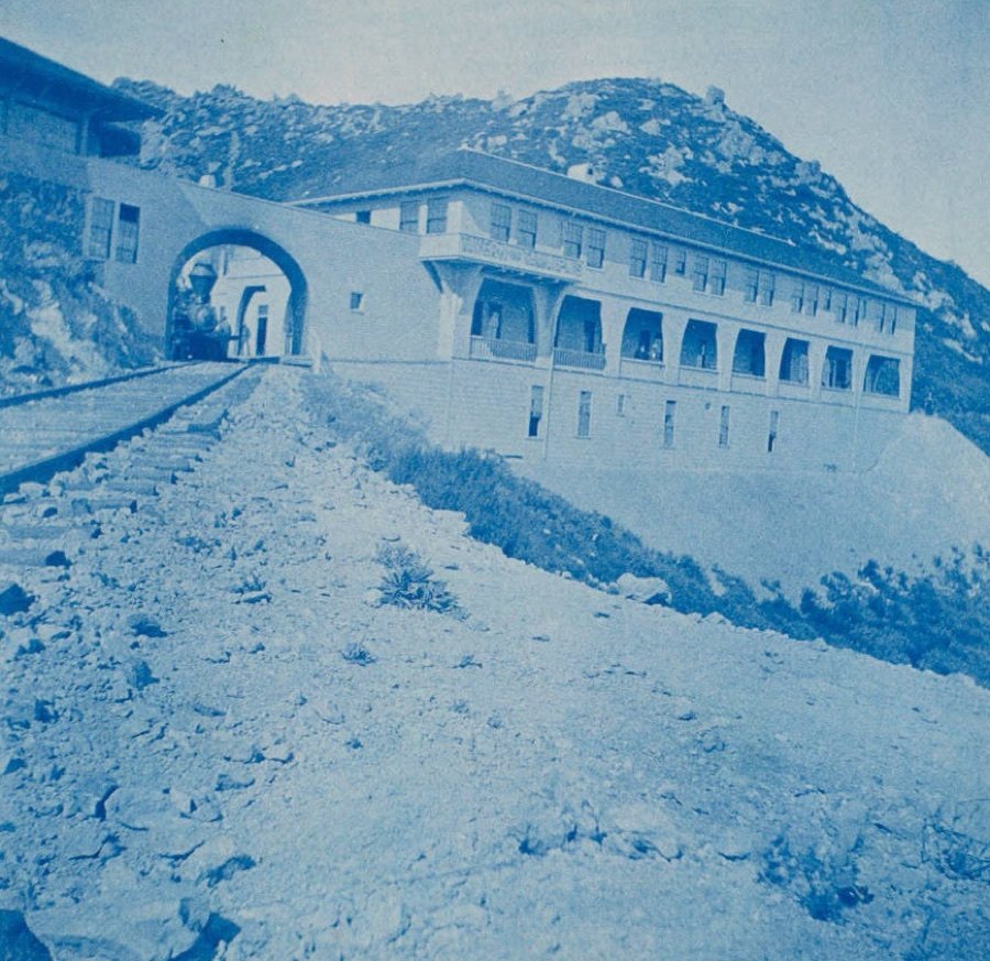 Cyanotype: the railway tracks running through the arched bridge to the long Tavern building below the summit rocks