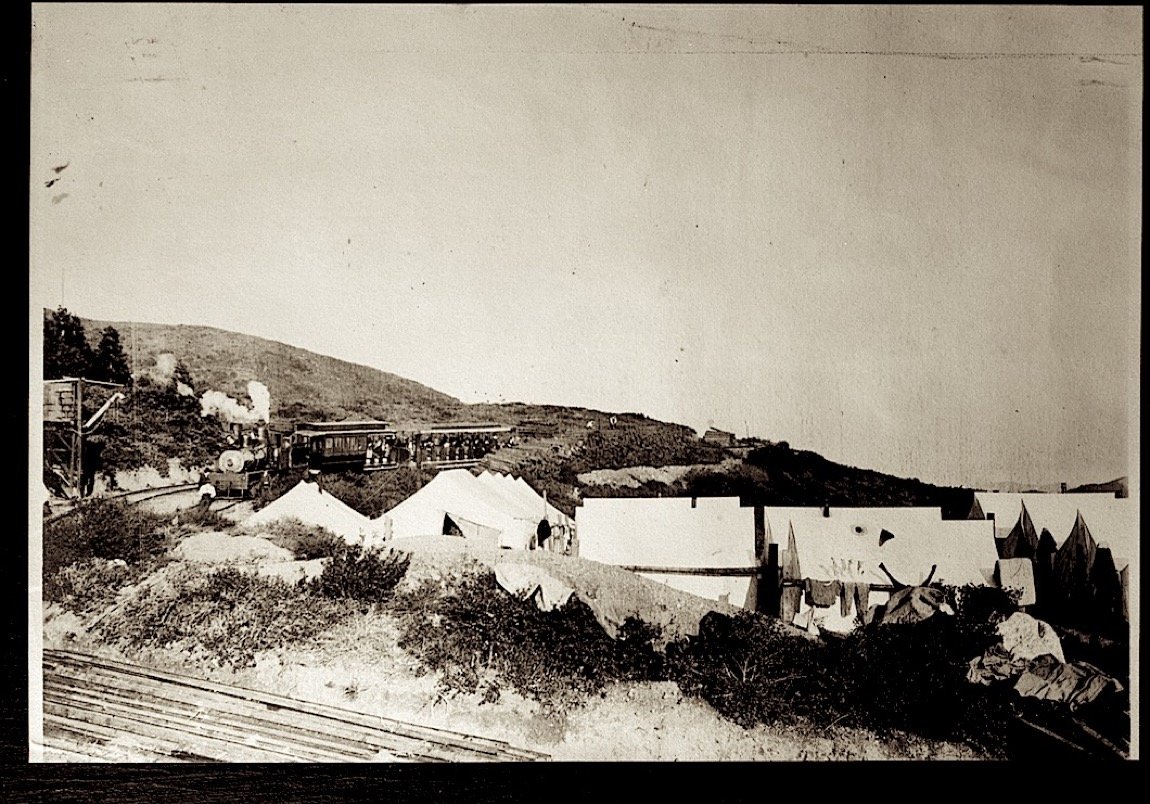 Tents and sheds beside the track at Mesa Station on the hillside