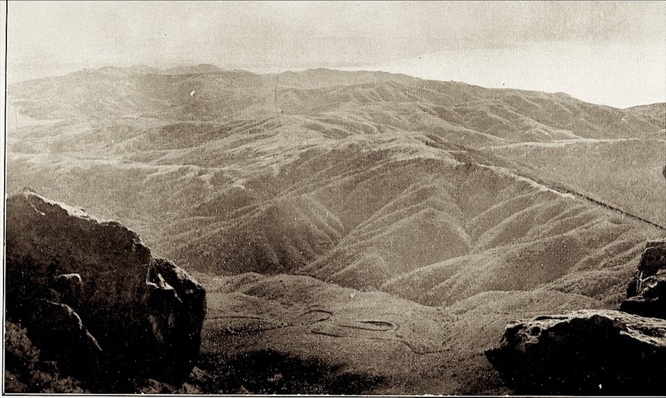 Ridges rolling away below rocks at the summit